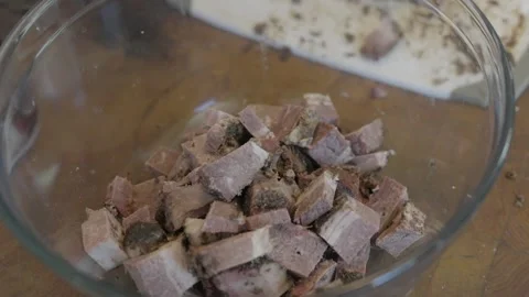 Close up hand throws beef into glass bowl Stock Footage 250832461