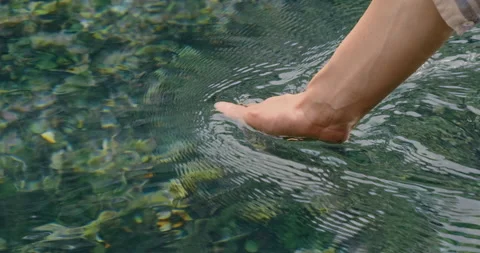 Close-up, hand touching clear water of fast river in mountain. Woman's hand Stock Footage 193433271