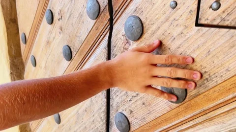 Close-Up of Hand Touching Keyhole and Iron Studs on Heavy Wooden Door Stock Footage 344235537