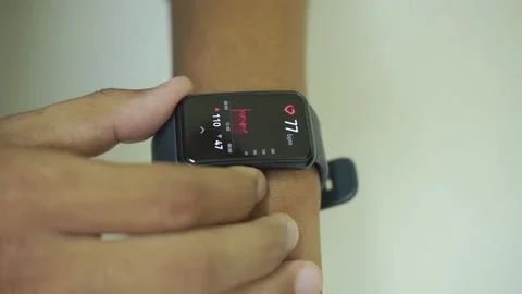 Close up of hand touching smartwatch with heart rate checking app on the screen. Stock Footage 322116012