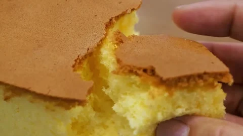 Close-up of a hand touching a soft, fluffy, Japanese Castella sponge cake Stock Footage 331779851