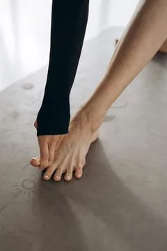 Close-Up of a Hand Touching Toes During Yoga Practice on a Mat Foto stock
