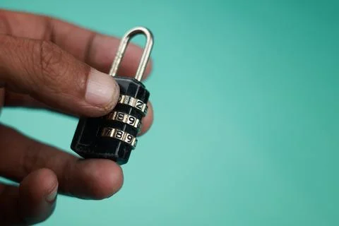 Close up hand try open black padlock with password 写真素材