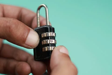 Close up hand try open black padlock with password Foto stock
