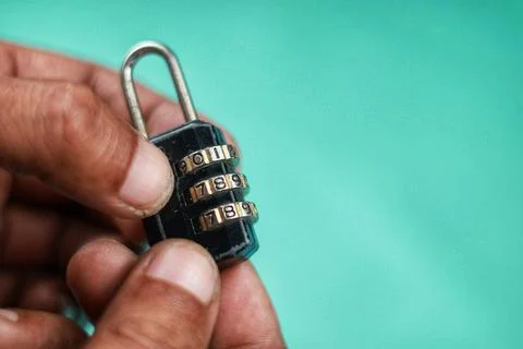 Close up hand try open black padlock with password Photos
