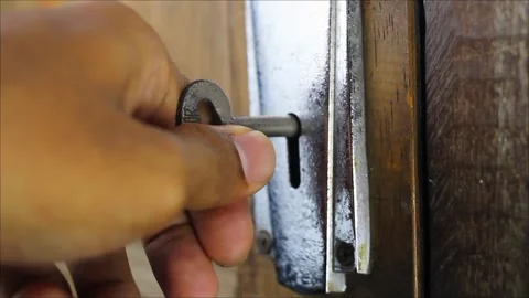 Close-up of hand trying to open wooden door with key Stock Footage 306458918