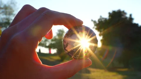 Close-Up of Hand Turning 3D Globe Puzzle Catching Sunset Rays Stock Footage 295117070