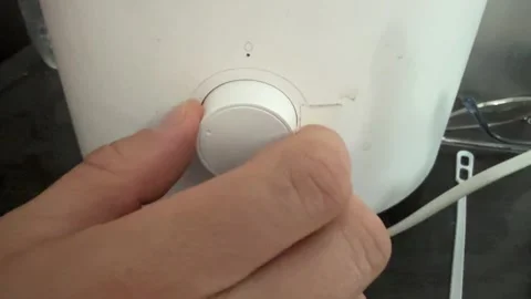 Close up hand turning control knob on electric home appliance. Adjusting Stockbeeldmateriaal 336978932