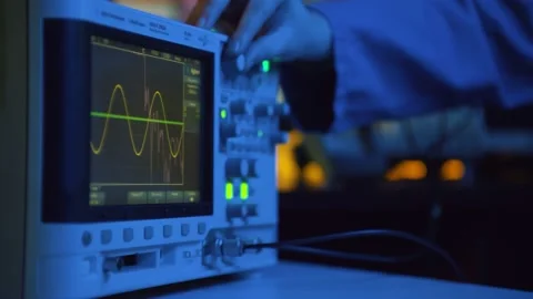 Close up of hand turning dial of modern electronic oscilloscope Stock Footage 136885830