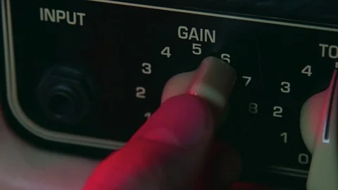 Close up of Hand Turning Gain Button up of Guitar Amplifier Stock Footage 124086959