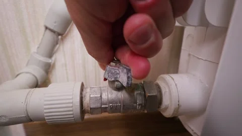 Close Up of Hand Turning Off Heating Radiator Valve in Home Interior Stock Footage 339212995