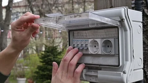 Close-up of a hand turning on a light switch and a light bulb in the garden 스톡 동영상 270974324