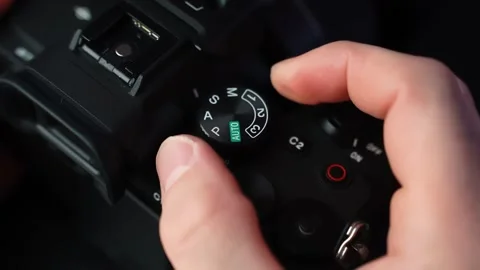 Close-up of hand turning the mode dial on a mirrorless camera, switching Stock Footage 328974737