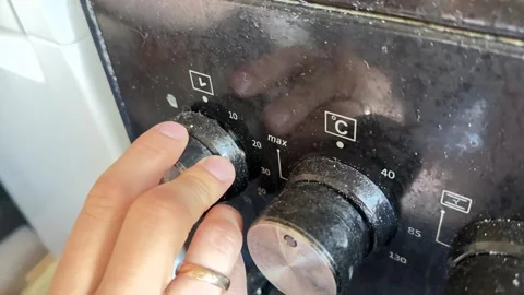 Close up of hand turning oven timer knob, setting cooking time on kitchen Stock Footage 337104505