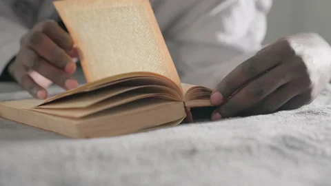 Close-up of hand turning pages of book while lying on bed in tranquil indoor Stock Footage 317191223