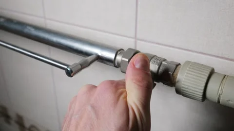Close Up of Hand Turning Radiator Valve on Metal Heating Pipe at Home Stock Footage 339211508
