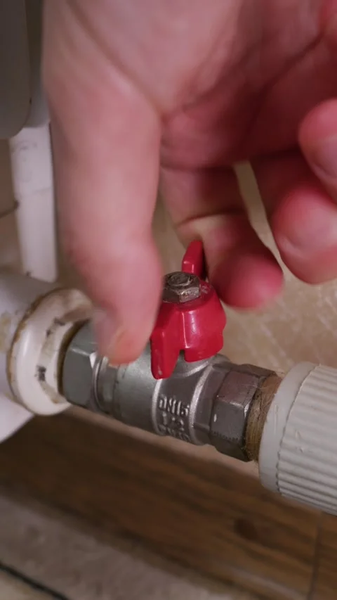 Close Up of Hand Turning Red Ball Valve to Open Heating Radiator Pipe Stock Footage 339213906