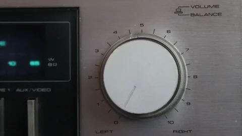 Close up of hand turning a volume knob on home stereo unit Stock Footage 126357346