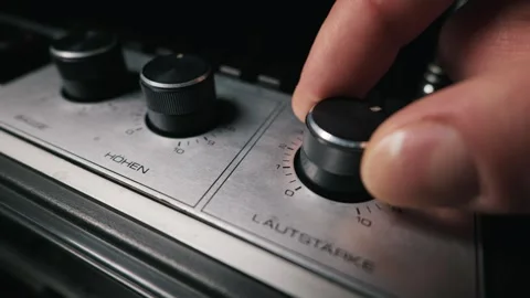Close Up of a Hand Turning the Volume Knob on a Vintage Audio Amplifier Vidéo 334110790