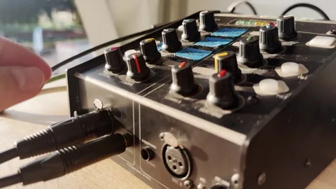 Close-up of a hand turning up the volume knob on a broadcast intercom unit Stockbeeldmateriaal 337738975