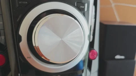 Close up of a hand turning the volume knob of a sound system. Listening Stock Footage 346410995