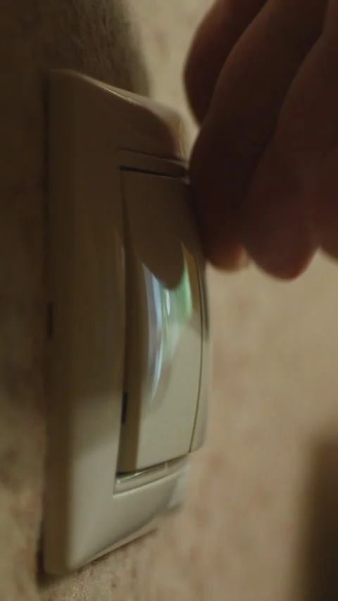 Close-Up Of A Hand Turning On A Wall Light Switch Indoors Stock Footage 304418232