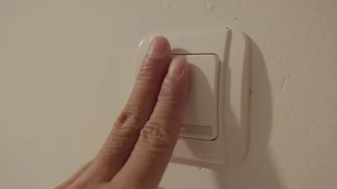 Close-up of a hand turning off a wall light switch at night Stock Footage 339197965