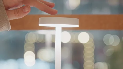 Close up of hand turning on white led touch sensor table lamp with soft ambient Stock Footage 345069415