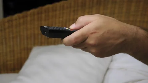 Close-up of a hand with TV remote controller switching TV channels. Slow motion Vídeo Stock 145277489