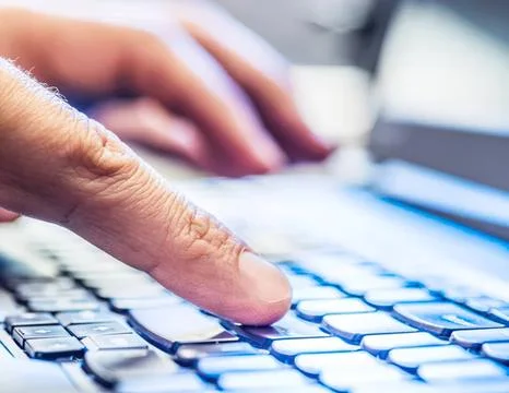 Close-up of hand typing on a computer keyboard Stock Photos
