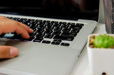 Close up hand typing a keyboard computer laptop on desk. Stock Photos