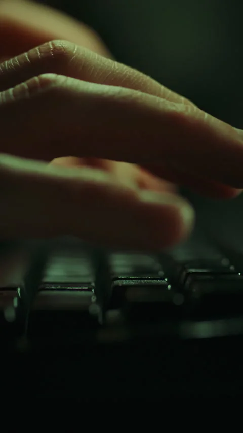 Close-up of hand typing on a keyboard in a dimly lit environment for tech en Stock Footage 331538973