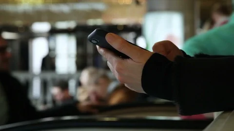 Close-up of a Hand typing a message in the phone, background a Big Store, winter Stock Footage 114212725