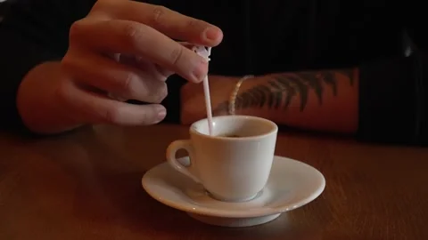 Close up on hand of unknown caucasian man stirring a cup of coffee Stock Footage 220808975