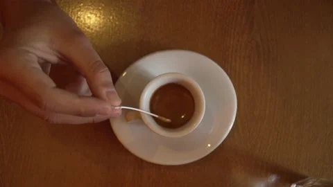 Close up on hand of unknown caucasian man stirring a cup of coffee Stock Footage 220808981