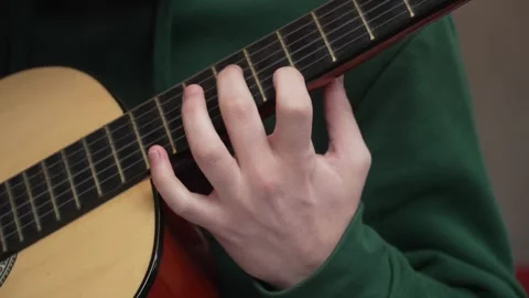 Close up on hand of unknown caucasian man hold and play guitar Stock Footage 242769476