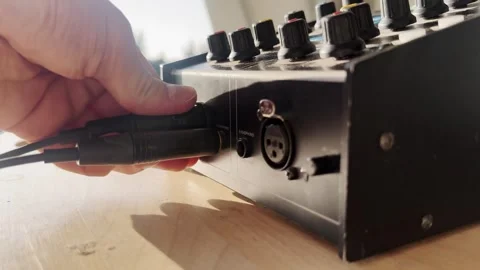 Close-up of a hand unplugging a cable from a broadcast intercom audio unit Stock Footage 336709593