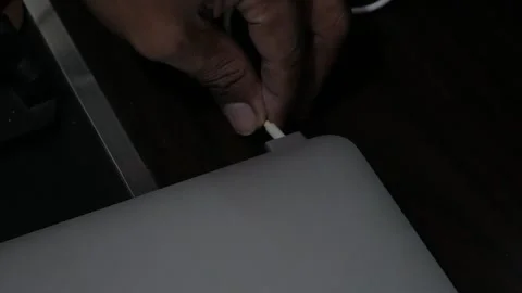 Close-Up of Hand Unplugging Power Charger Cable from Laptop Stock Footage 345012503
