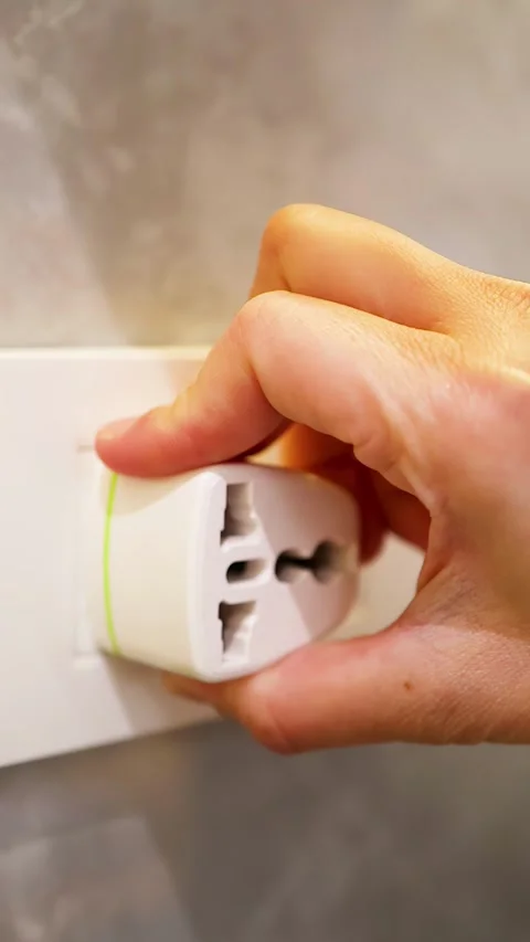 Close Up of Hand Unplugging Universal Travel Adapter from Wall Socket Stock Footage 333165136