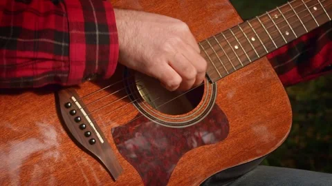 Close up hand of unrecognizable man plays at guitar and fingering strings Stock Footage 333514402