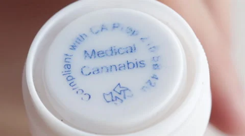 Close Up of Hand Unscrewing Cap on Bottle of Medical Marijuana Stock Footage 48437509