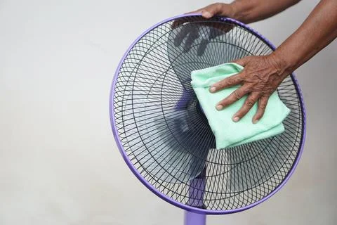 Close up hand use soft cloth to clean electric fan. Stock Photos