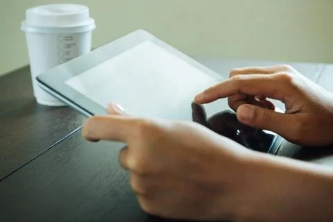 Close up hand use tablet on table Stock Photos
