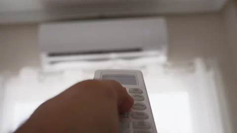 Close-up of hand using air conditioner remote control to adjust indoor temp.. Stock Footage 342440212