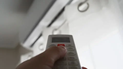 Close-up of hand using an air conditioner remote control to activate a cool.. Stock Footage 342762485