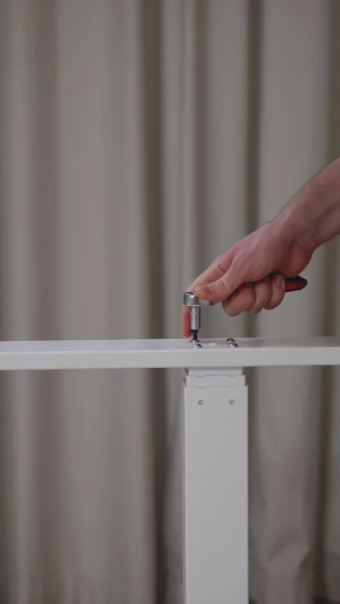 Close-up of a hand using an Allen wrench to assemble a piece of white furniture Stock Footage 293102831