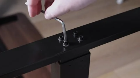 Close-up of a hand using an Allen wrench to tighten a screw on a sleek blac.. Stock Footage 322921374