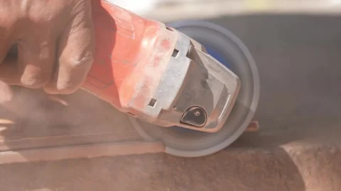 Close-up of a hand using an angle grinder to cut metal, sparks blurred in warm l Stock Footage 333330461