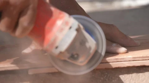 Close-up of a hand using an angle grinder to cut metal, sparks blurred in warm l Stock-Footage 333330467