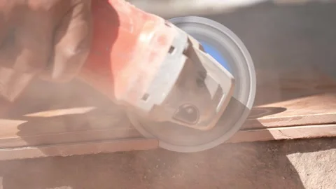 Close-up of a hand using an angle grinder to cut metal, sparks blurred in warm l Stock-Footage 333330468